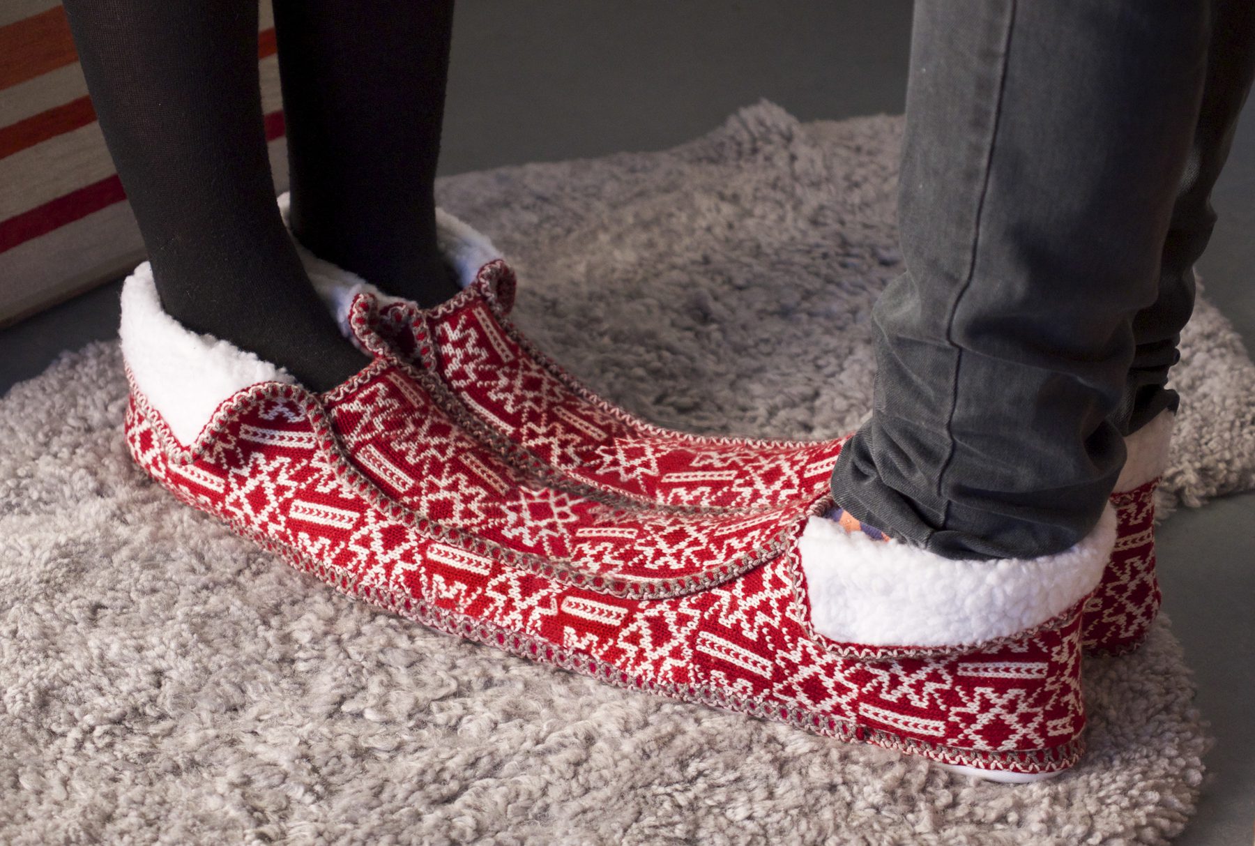 Two odd red knitted socks side by side